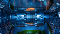 Blue light reflects off metallic surface details of the bellows inside the Spallation Neutron Source Power Proton Upgrade cryomodule inside the SRF Institute at Jefferson Lab in Newport News