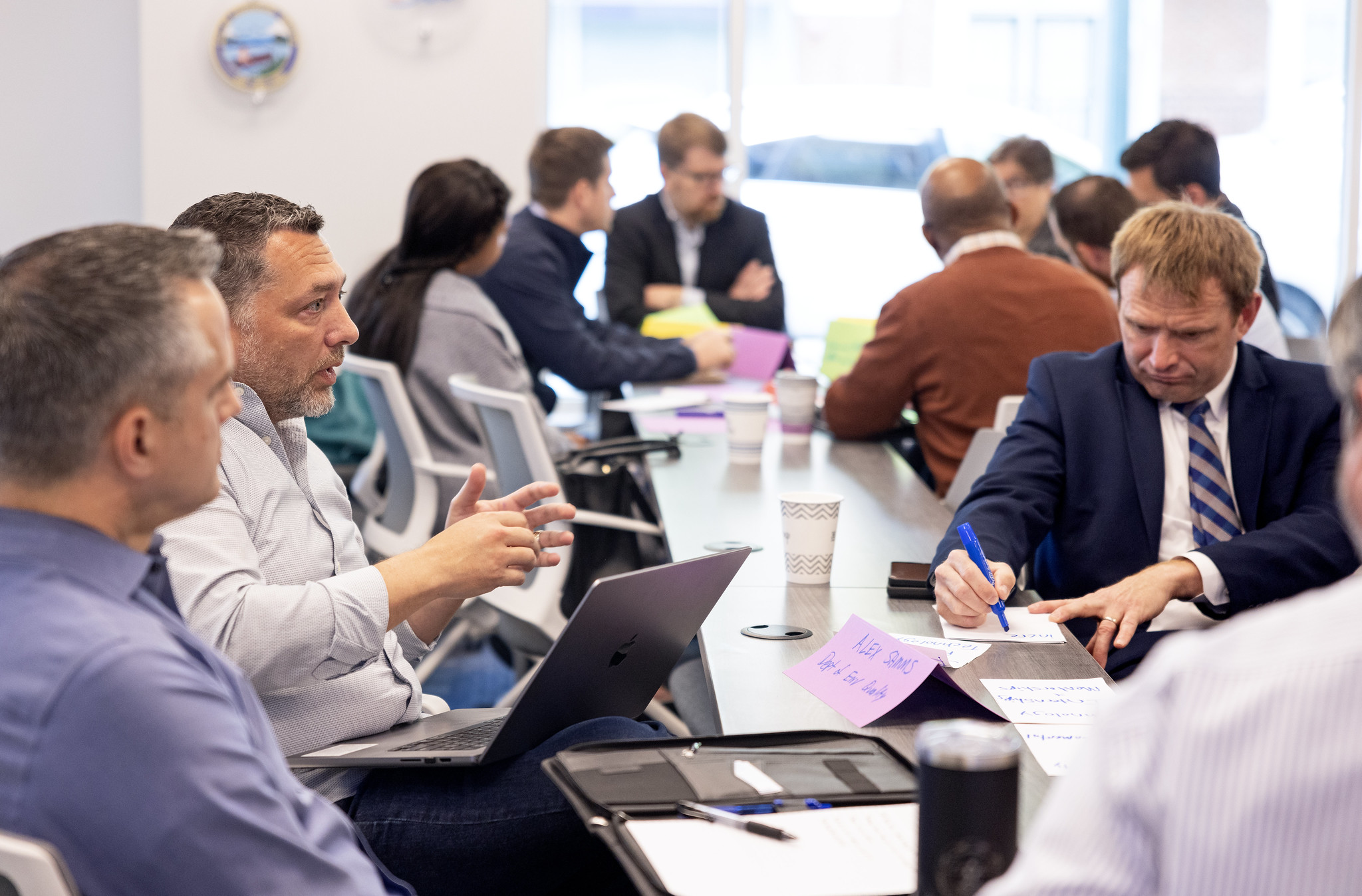 Jefferson Lab Business and Portfolio Development Associate David Perkins, second from left, chats with his group during the Department of Energy (DOE) Boost Platform Workshop in Newport News, Va., on Thursday, April 25, 2024.