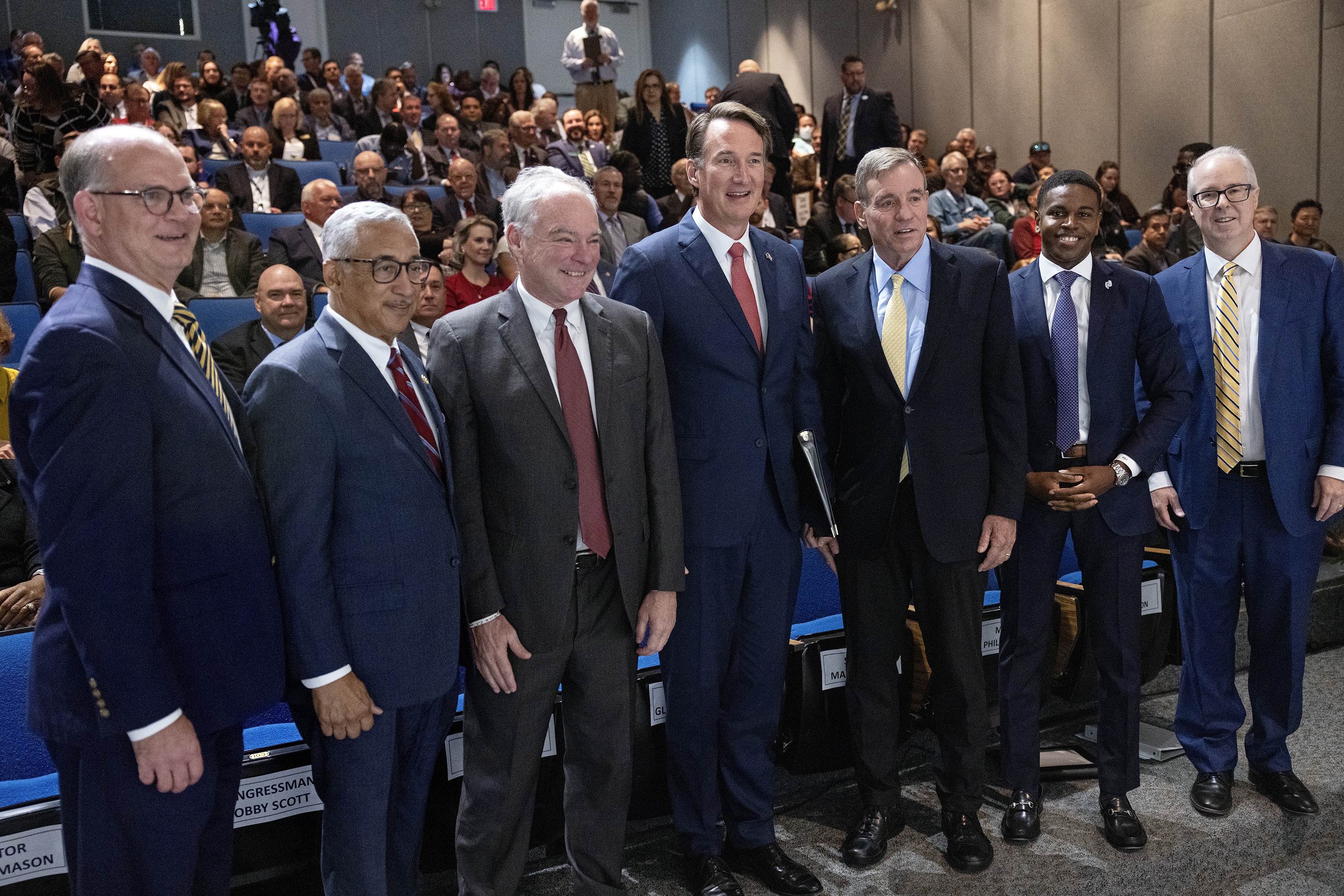 Honored speakers take a moment before the event. Included here (l-r) are Virginia State Senator Monty Mason, U.S. Representative Bobby Scott, U.S. Senator Tim Kaine, Commonwealth of Virginia Governor Glenn Youngkin, U.S. Senator Mark R. Warner, Newport News Mayor Phillip Jones, and Jefferson Lab Director Stuart Henderson.